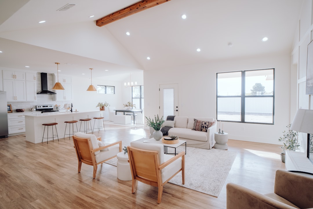A bright and tidy living room with organized furniture and decorative plants, showcasing a clean and inviting atmosphere.